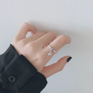Anillo ajustable plateado con colgante de sonrisa y detalle de rayas negras