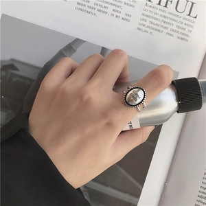 Anillo ovalado vintage plateado grabado con 'Good Luck' y doble banda calada en una modelo