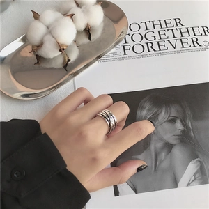 Anillo vintage de plata multicapa en bandeja plateada con algodón y una revista