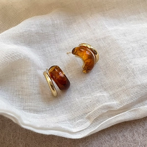 Vista detallada de los pendientes vintage dorados con resina ámbar de textura mármol