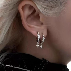 Pendientes de aro en plata con colgantes de estrella texturizados en una modelo