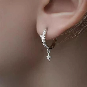 Pendientes de aro con colgante de estrella y circonitas lucidos por una modelo real