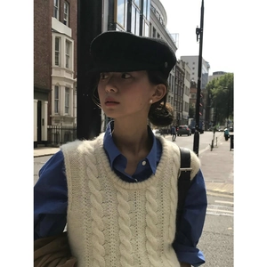 Chaleco de punto trenzado crema de estilo vintage francés usado por una modelo