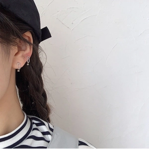 Boucles d'oreilles minimalistes en U argentées portées pour un style chic et tendance