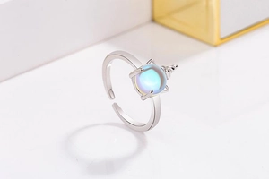 Close-up of adjustable silver unicorn ring with iridescent moonstone and horn detail