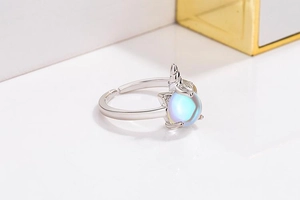 Macro shot of silver unicorn ring with iridescent moonstone and adjustable band detail