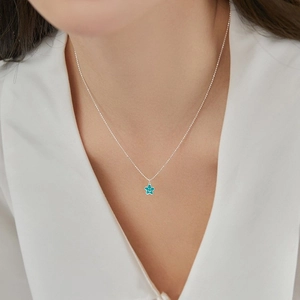 Dettaglio del ciondolo a stella in smalto blu con smile su catena a sfere d'argento