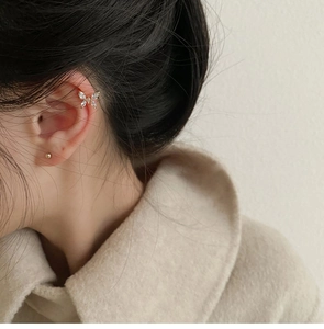 Detalle de earcuff de mariposa con circonitas brillantes en un acabado dorado