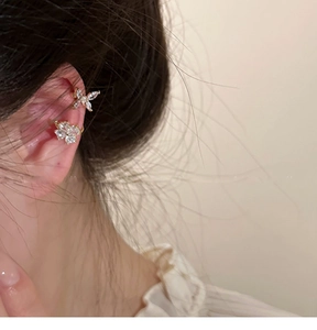 Primer plano de ear cuffs de mariposa dorada con circonitas brillantes en la oreja