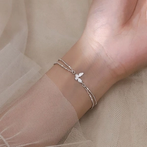 Elegantes zweischichtiges Silberperlenarmband mit einem Schmetterlingsanhänger und Kristallen