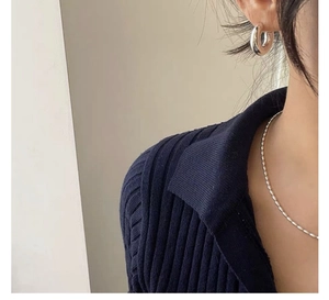 Close-up of S925 silver rice bead necklace and thick hoop earrings on a model