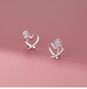 Macro detail of heart-shaped clip-on earrings with soft silicone pads and silver finish