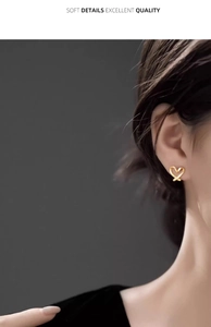 Close-up of elegant gold hollow heart clip-on earring worn on model's ear