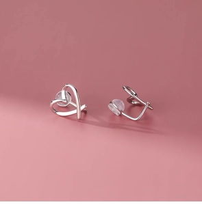 Macro view of silver heart-shaped clip-on earrings with comfortable silicone pads