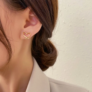Close-up of golden hollow heart ear clip on ear showing elegant minimalist design
