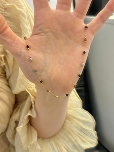 Primo piano di una collana girocollo di perline colorate con catena dorata