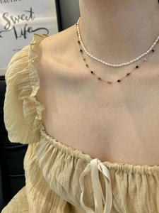 Dettaglio del girocollo a strati con perle e perline colorate sul collo della modella
