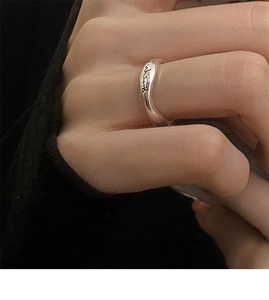 Macro detail of silver irregular lava ring with delicate cursive wing engraving