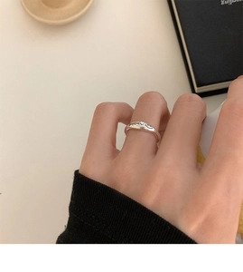 Close-up of a silver smiley face ring with smile engraving worn on a finger