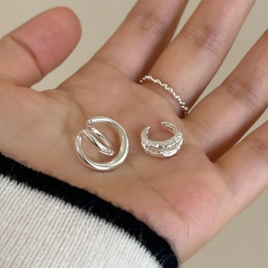 Minimalist silver ear cuff set and beaded ring shown on a model for daily layering