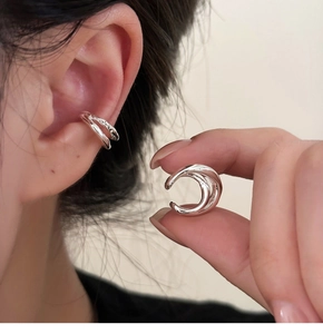 Detail of silver double-layered ear cuff showing polished finish on human ear