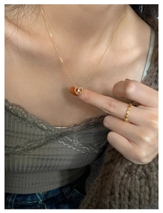 Detail of gold pretzel pendant necklace with micro-paved crystal and matching ring