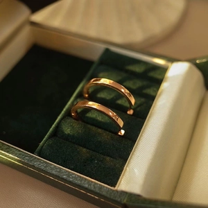 Primer plano de pendientes de aro en oro rosa en un estuche de terciopelo verde
