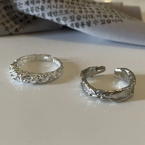 Detalle macro de anillos bañados en plata 925 con textura de lava y diseño abierto ajustable