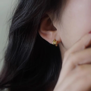 Minimalistische doppellagige Goldohrringe mit poliertem Finish am weiblichen Model