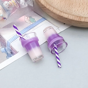 Macro detail of two miniature purple bubble tea resin charms for DIY jewelry making