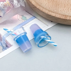 Close-up of DIY resin bubble tea charms with blue and purple gradient and straw detail