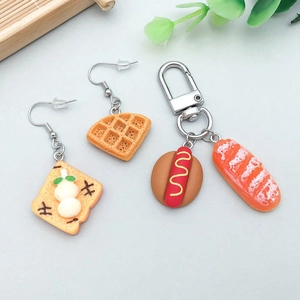 Detailed view of colorful resin food charms featuring waffle and hotdog shapes for DIY