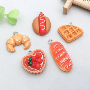 Detailed view of colorful resin food charms like croissants and waffles for DIY jewelry