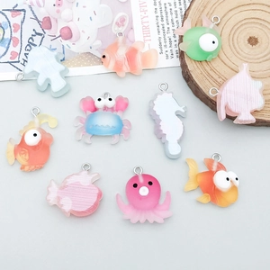 Detailed view of colorful resin sea animal charms on rustic wooden background