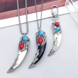 Close-up of bohemian style ivory and black tooth pendants with vintage silver metalwork