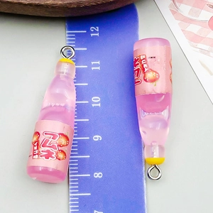 Pink resin strawberry drink bottle charm with metal ring measuring 2.8cm on ruler