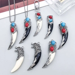 Detail of vintage wolf tooth pendants with engraved silver alloy and colorful beads