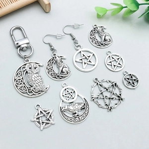 Makroaufnahme gotischer Silberanhänger mit Motiven von Mond, Wolf und Pentagrammen