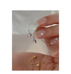 Detailed view of lily of the valley earrings in silver and gold polished finishes