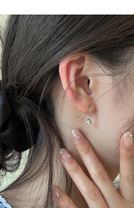 Close-up of elegant lily of the valley earrings worn by a model in silver finish