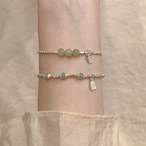Details von silbernen Armbändern mit Jade-Perlen und chinesischen Segen-Anhängern