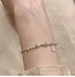 Nahaufnahme eines Silber-Perlenarmbands mit Jadeperlen und Pingan-Anhänger