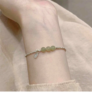 Nahaufnahme eines S925 Silberperlenarmbands mit Hetian Jade am Handgelenk