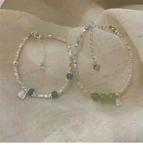 Nahaufnahme von S925 Silberperlenarmbändern mit grünen Edelsteinen und Hope-Anhänger