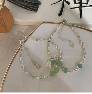 Detail von S925 Silberperlenarmbändern mit Hetian-Jade und Fu-Anhänger auf Porzellan
