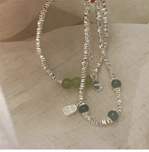 Detail von S925 Silberarmband mit unregelmäßigen Perlen und grünen Jade-Steinen
