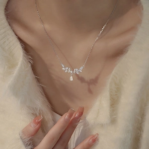 Silver leaf necklace with marquise gemstones and drop pendant on female model