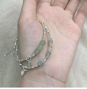 Detail von Silberperlen-Armbändern mit Jade-Perlen und graviertem Segen-Anhänger