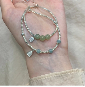 Detail eines Silberarmbands mit Hetian-Jade-Anhängern und Fu- sowie Pingan-Gravuren