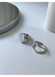 Detalle de anillos de plata S925 con incrustación de nácar y grabado de marca